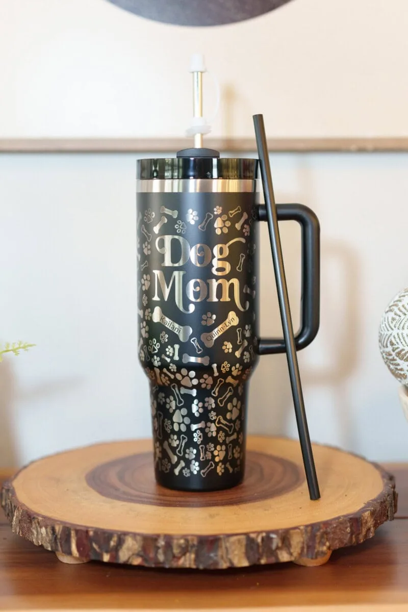 Engraved stainless steel dog mom tumbler with pet names and pictures, perfect for dog lovers.
