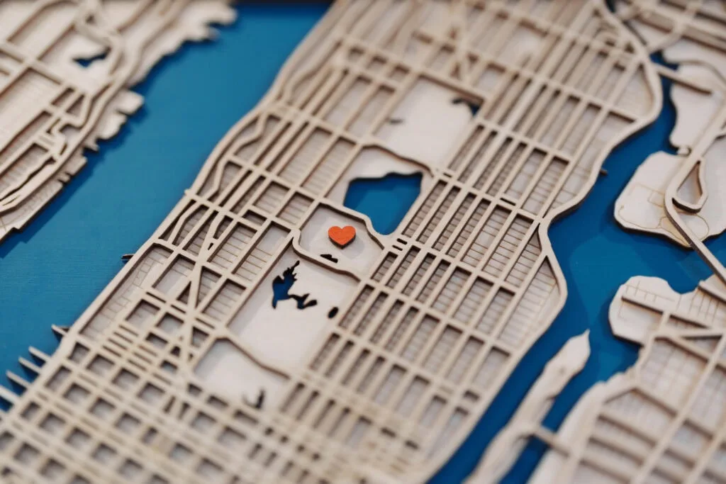 Laser cut map of shoreline with detailed street layout and a small red heart marker.