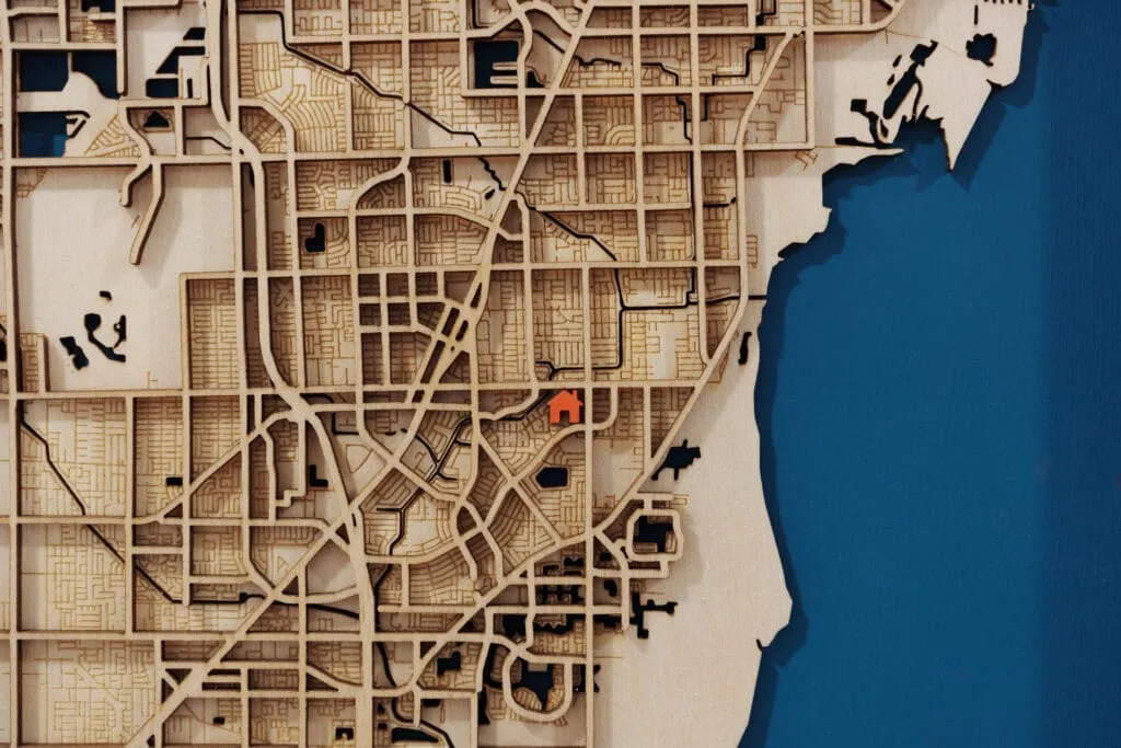 Laser cut map of shoreline city with detailed street layout and waterfront features.