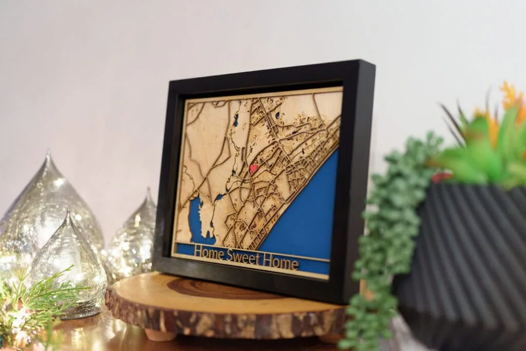 Custom laser cut map art of a coastal area with water and land details.