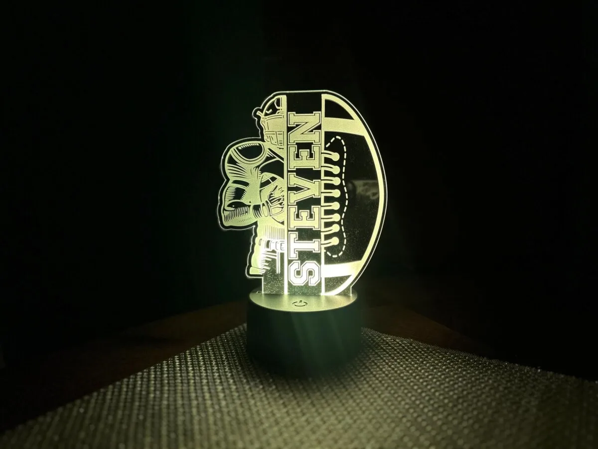 Custom laser-engraved Shoreline Laser Designs logo with lighthouse and wave elements.
